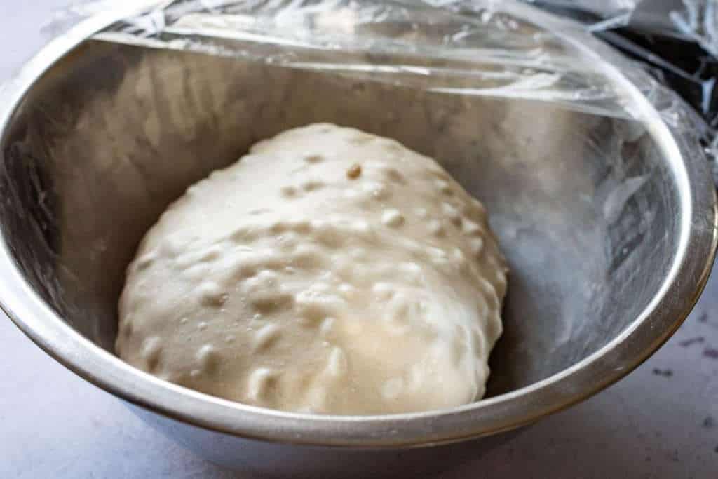 Sunflower sourdough after the last fold being covered with plastic wrap for finishing bulk fermentation.