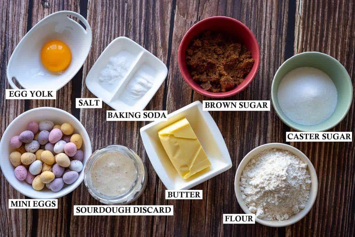 Ingredients for Sourdough Discard Cookies With Mini Eggs on a wooden surface.
