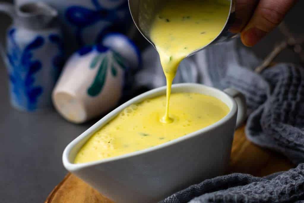 Pouring the creamy sauce into a gravy boat.