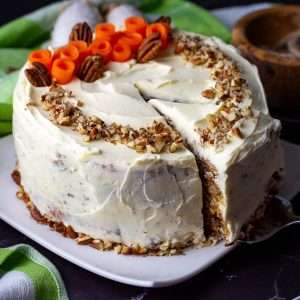 A slice of sourdough carrot cake being cut.