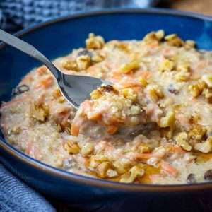 Carrot Cake Porridge being scooped up by a spoon from a blue bowl.