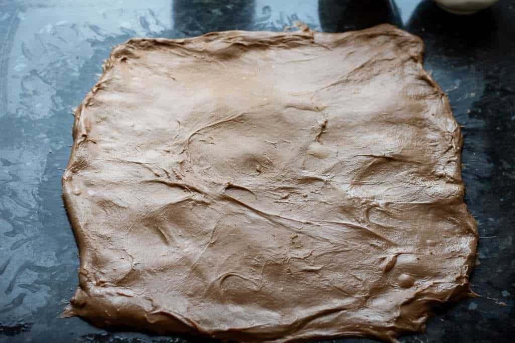 Chocolate sourdough stretched out into a rectangle on the kitchen surface.