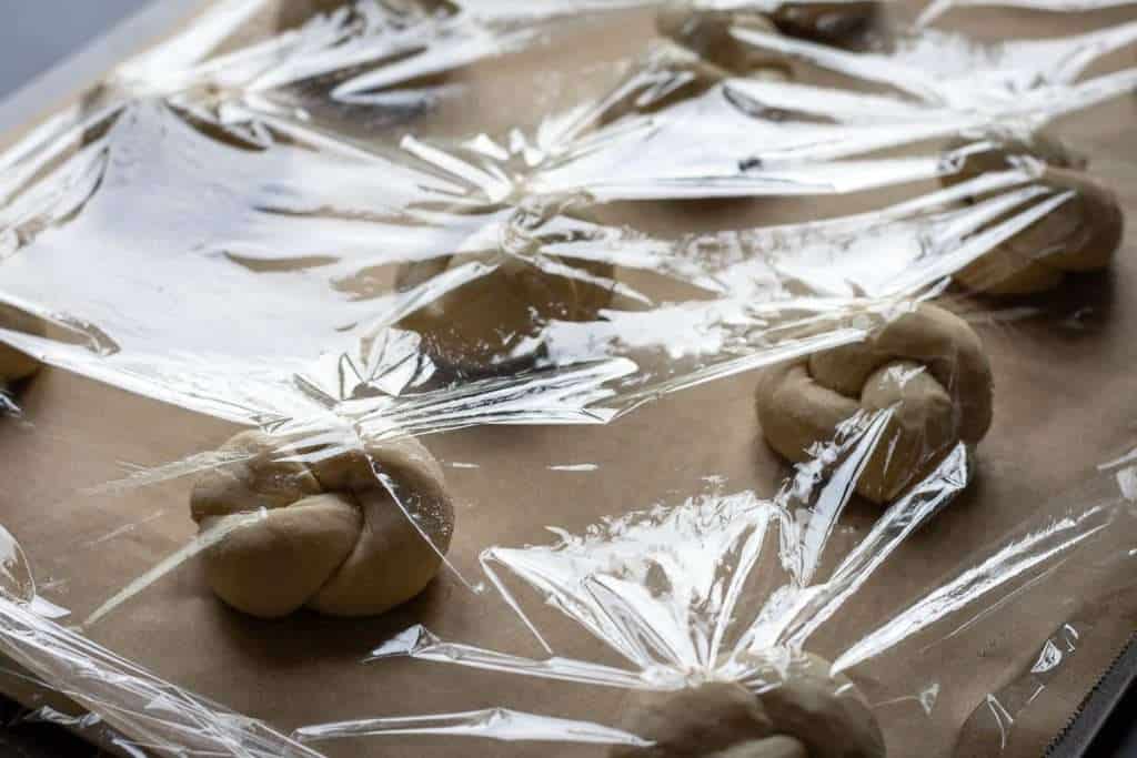Sourdough knots covered with lightly oiled cling film.