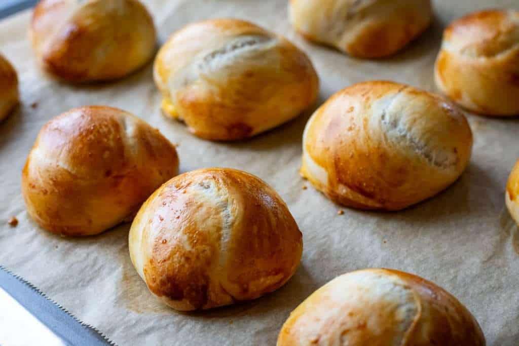 Baked sourdough knots on a parchment paper lined baking sheet.