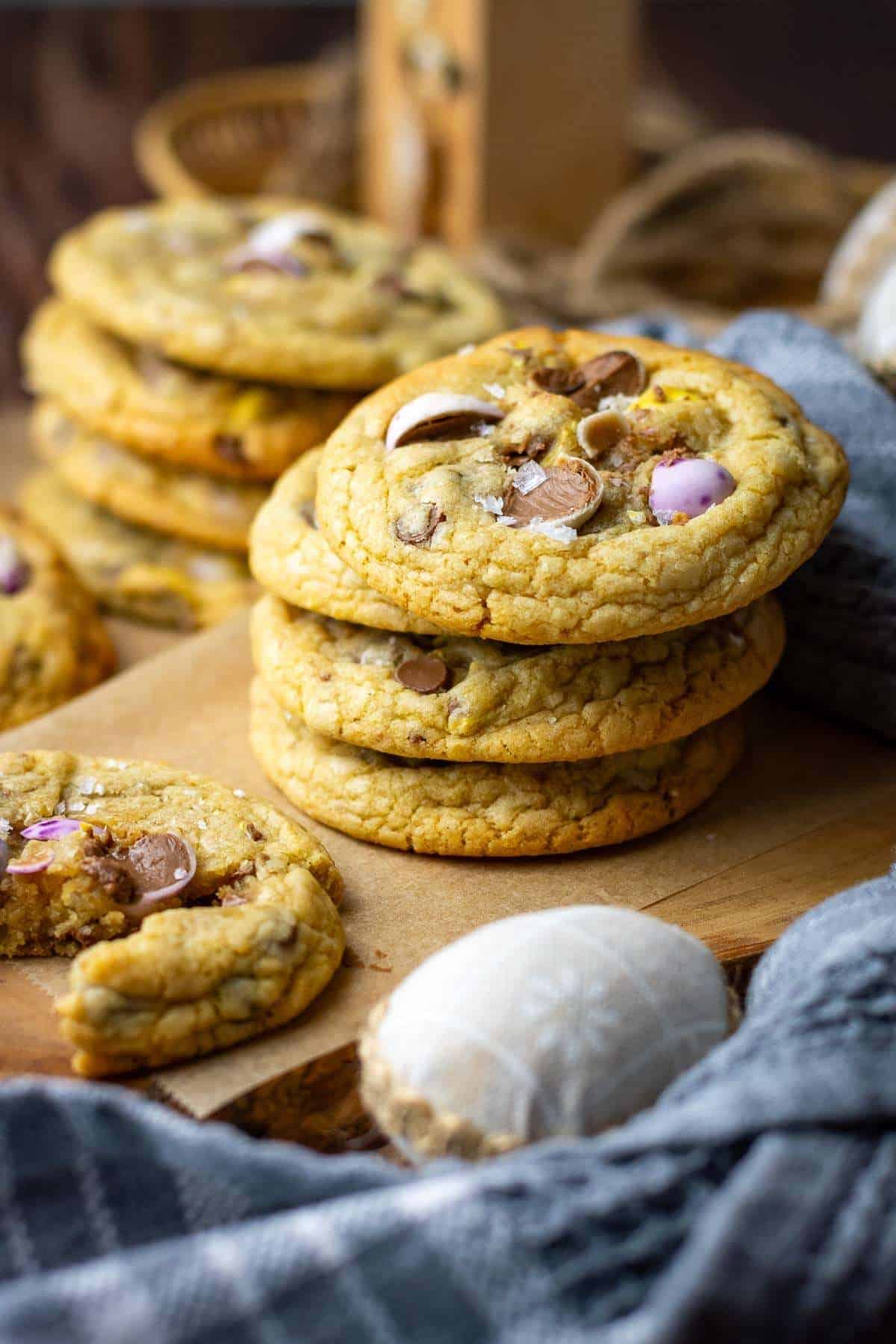 Stacks of Easter cookies with mini eggs on a table decorated for Easter.