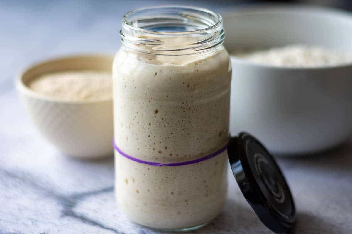 Active sourdough starter in a jar with a rubber band on.