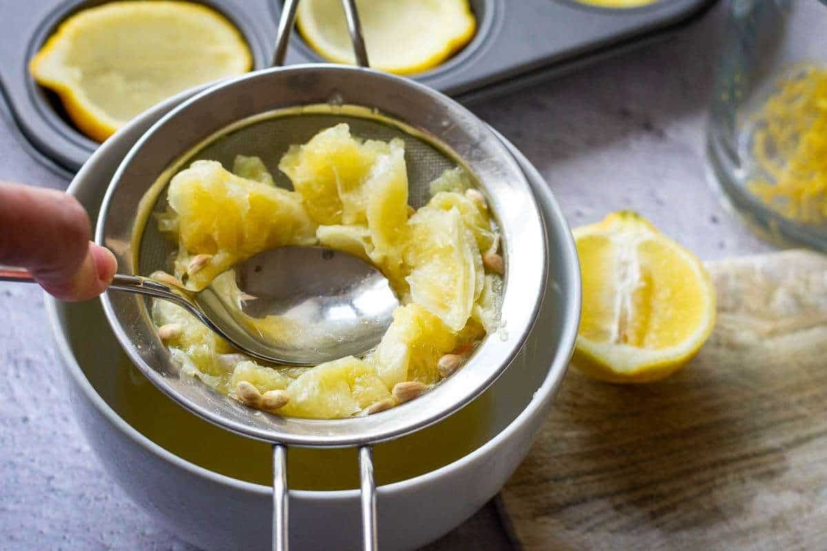 Pressing the lemon flesh through a fine lieve to get the juice.