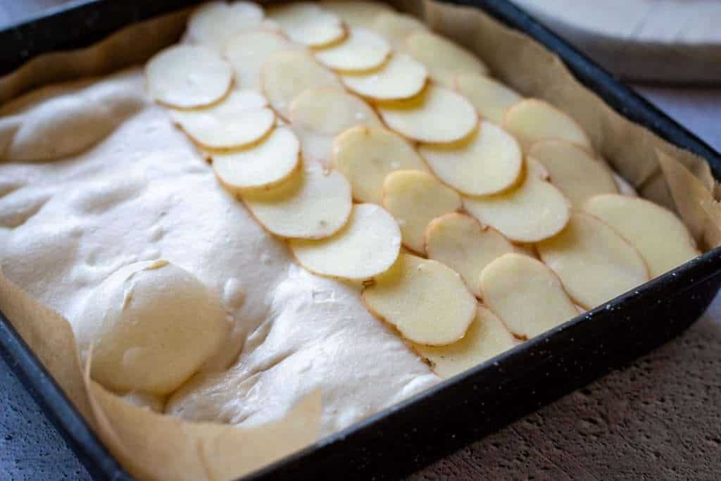 Half of the sourdough focaccia covered with overlapping potato slices.