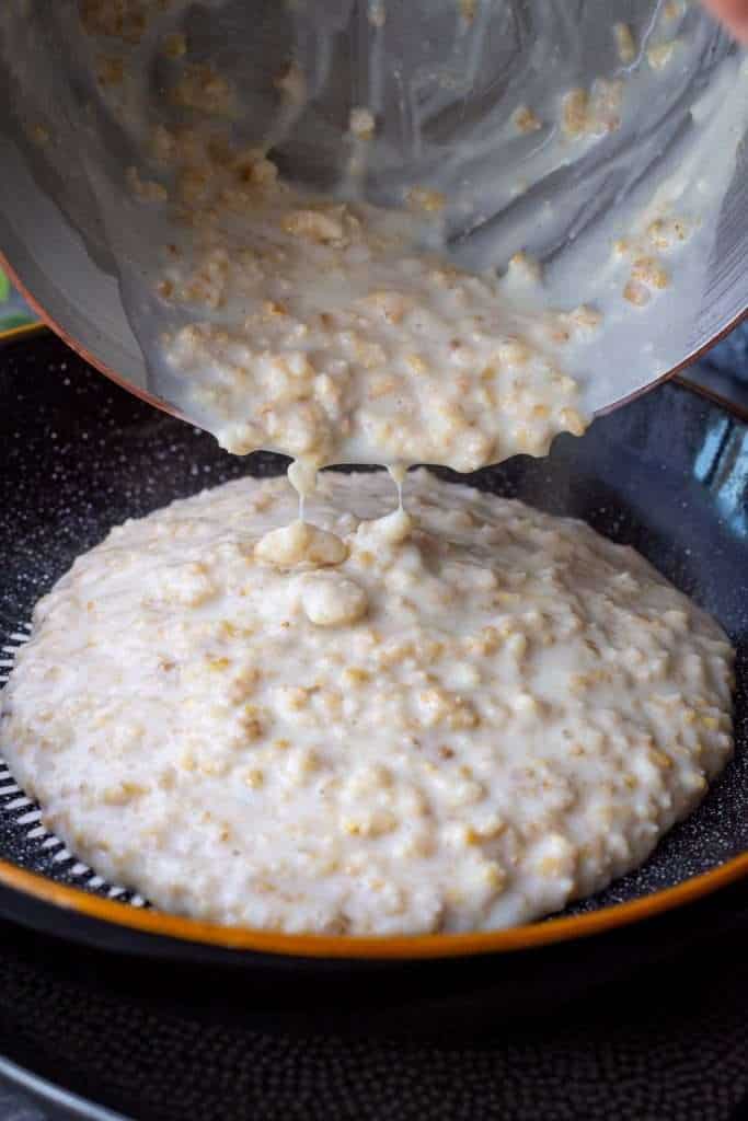 Creamy oat porridge with almond flour being poured into a bowl.