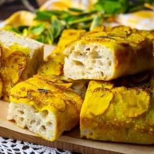 Turmeric potato and rosemary sourdough foaccia sliced into squares.