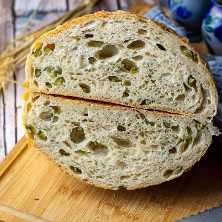 Dill Pickle Sourdough Bread cut in half exposing pickles in the interior.