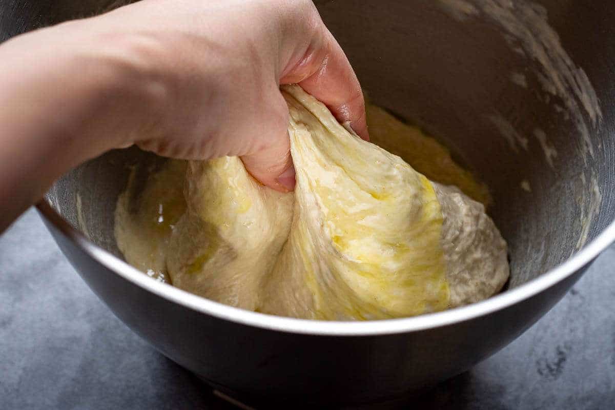 Squishing the olive oil into the sourdough with my hands in a stand mixer bowl.