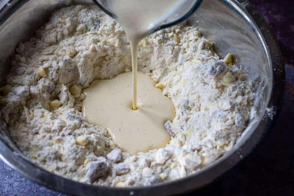 POuring in the wet ingredients in the well of the flour.