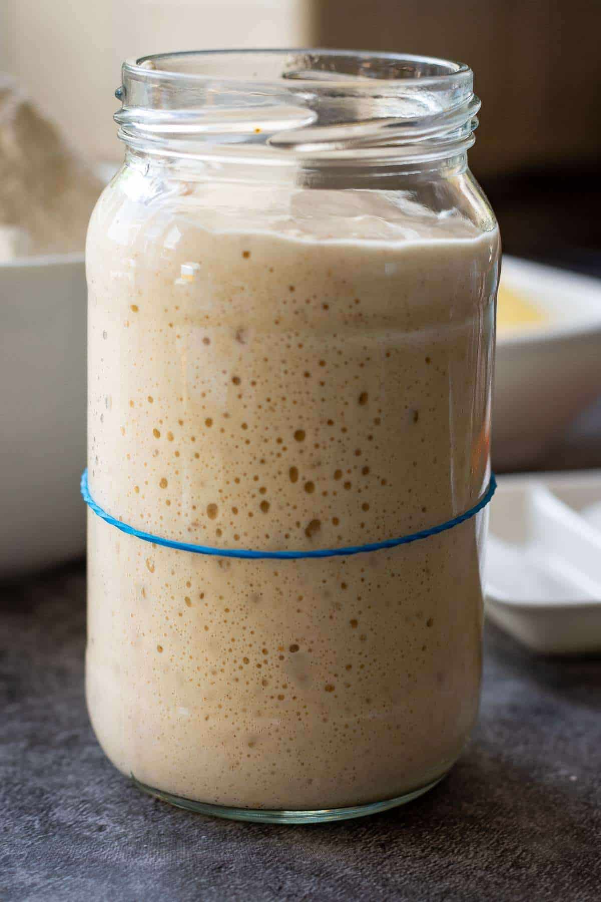 Doubled sourdough starter in a glass jar.