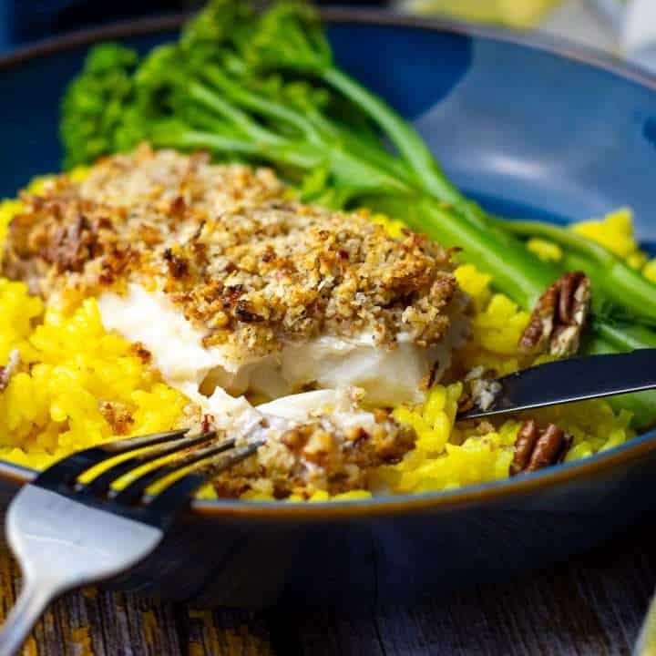 Pecan crusted fish being cut into.