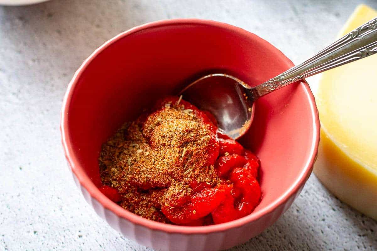 Fajita spice flavoured pizza sauce in a small red bowl.