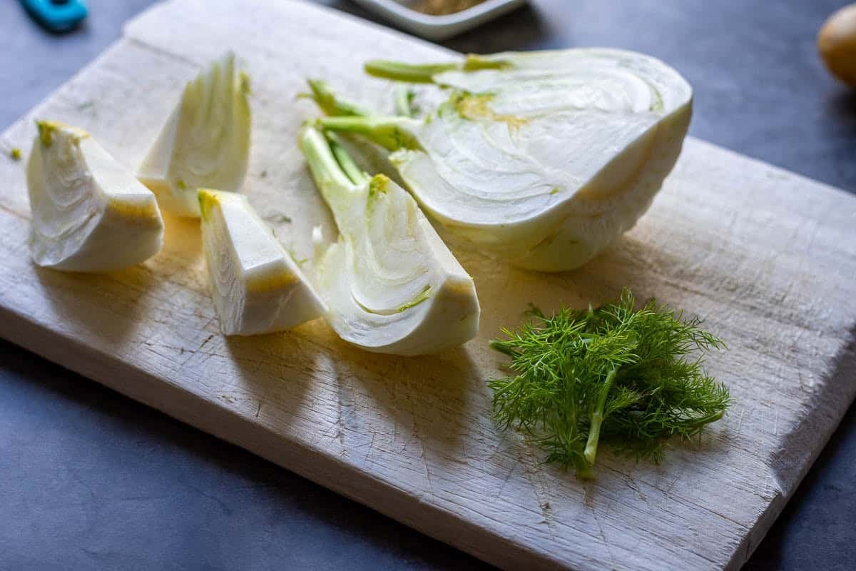 Cutting fennel on a wooden chopping board.