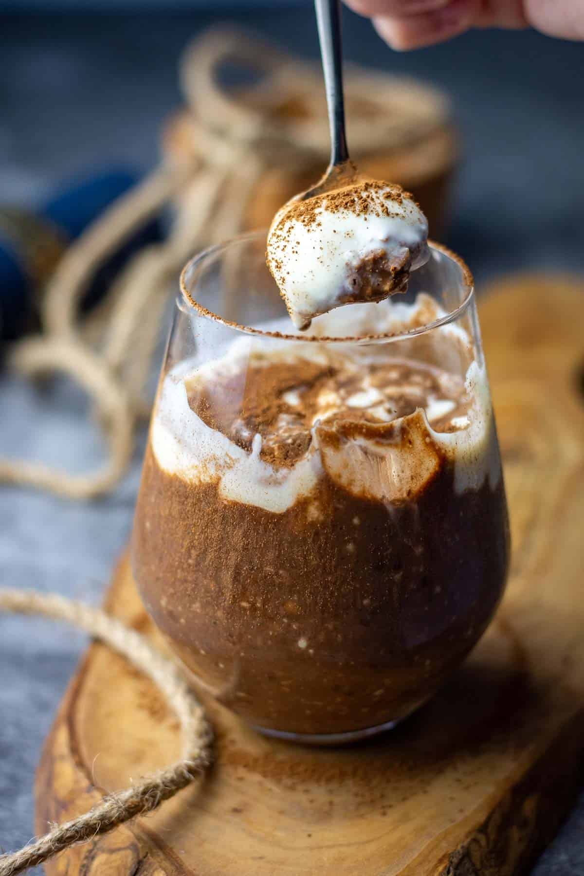 A spoonful of tiramisu overnight oats lifted out of a glass.