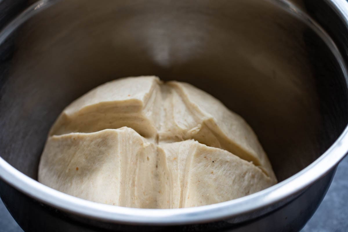 Scored sourdough detrempe in a metal bowl.