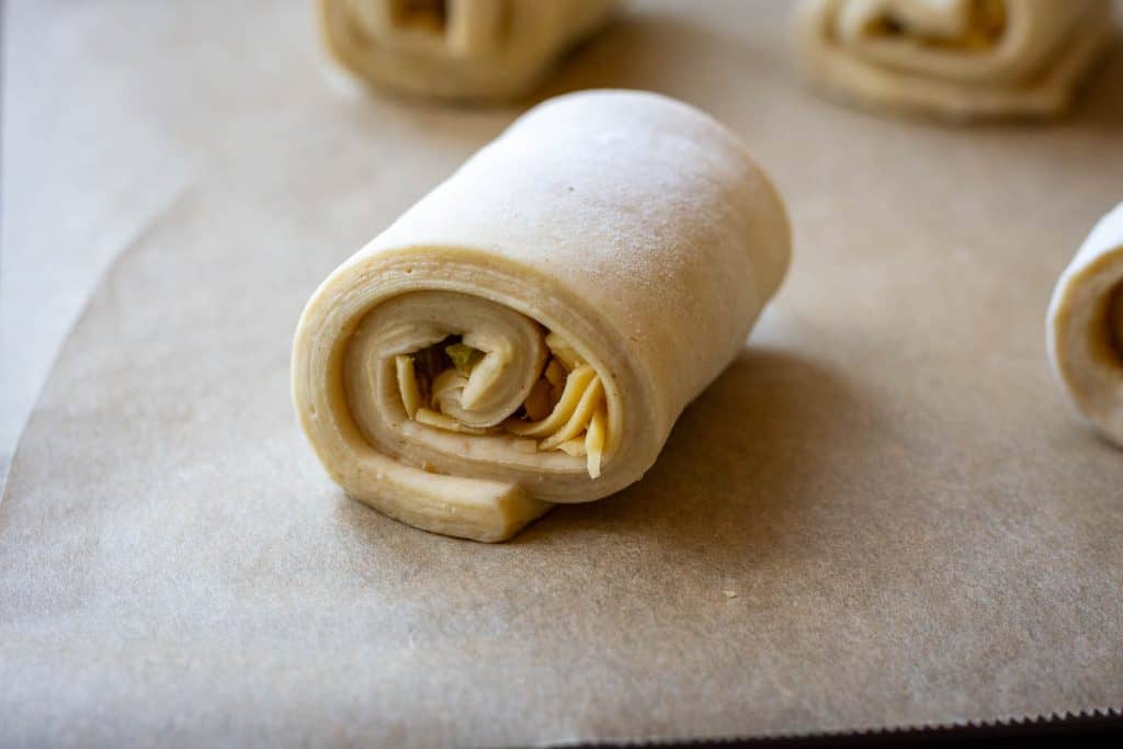 Shaped Jalapeno and Cheddar Sourdough Croissant on a baking parchment lined baking sheet.