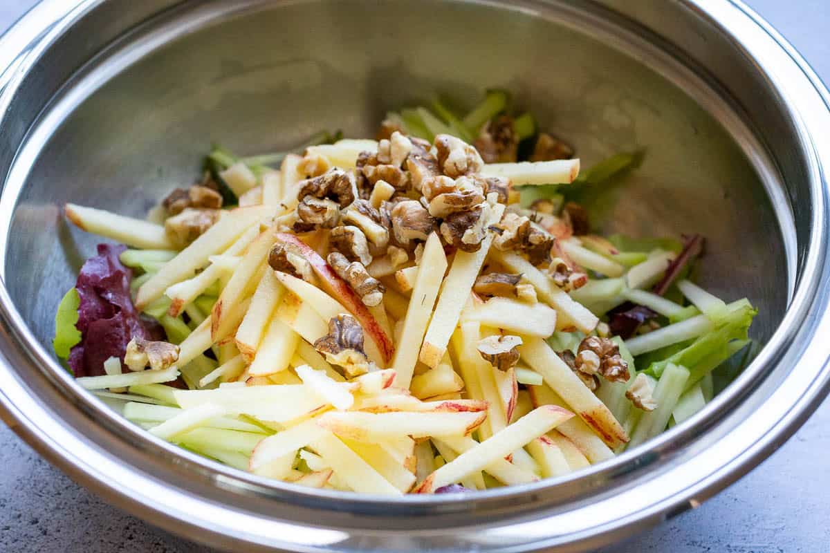 Kohlrabi and apple salad ingredinets in a large mixing bowl.