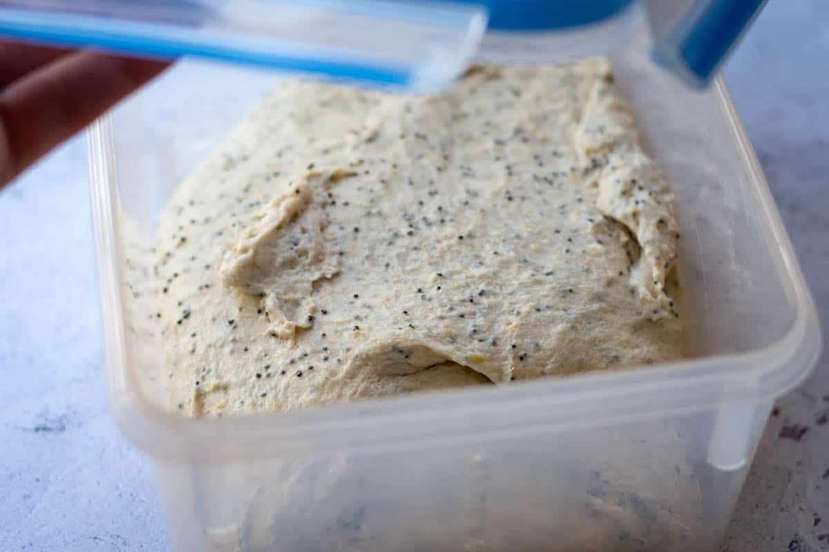 Sourdough with lemon zest and poppy seeds in a plastic box right after initial mixing.