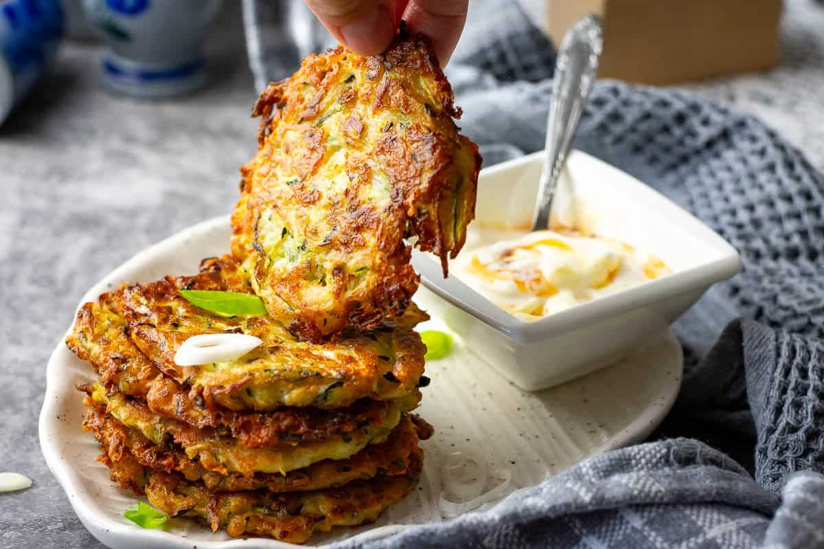 Picking up one sourdough courgette fritter from the stack.