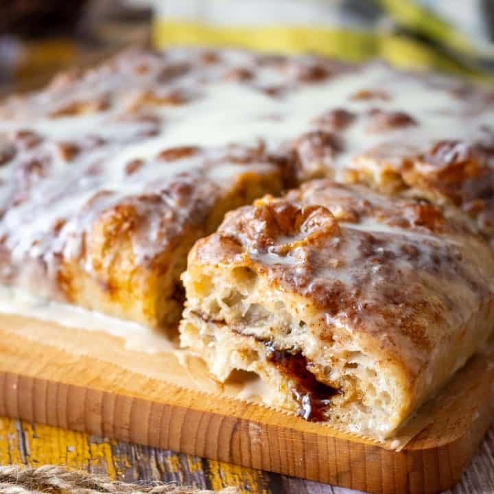 A slice of cinnamon sourdough focaccia with cinnamon sugar dripping down frothe inside.