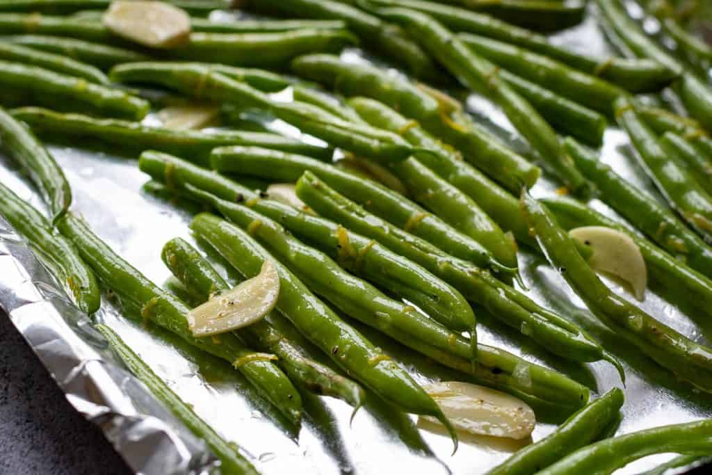 Green beans spread on a baking tray.