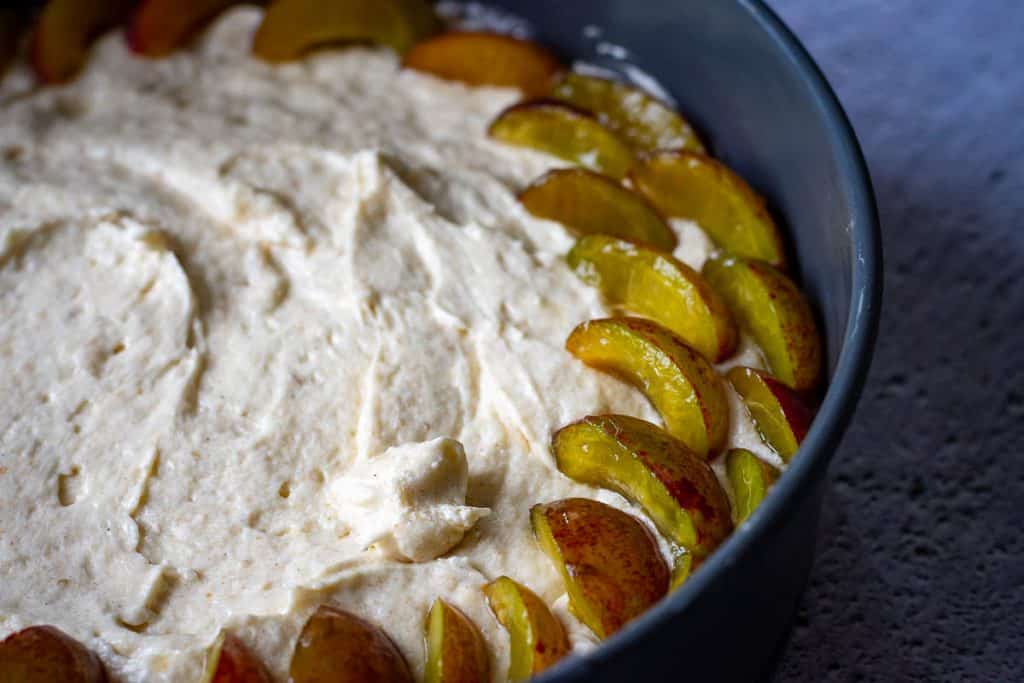 Arranging plum quanters on the sourdough discard cake batter.
