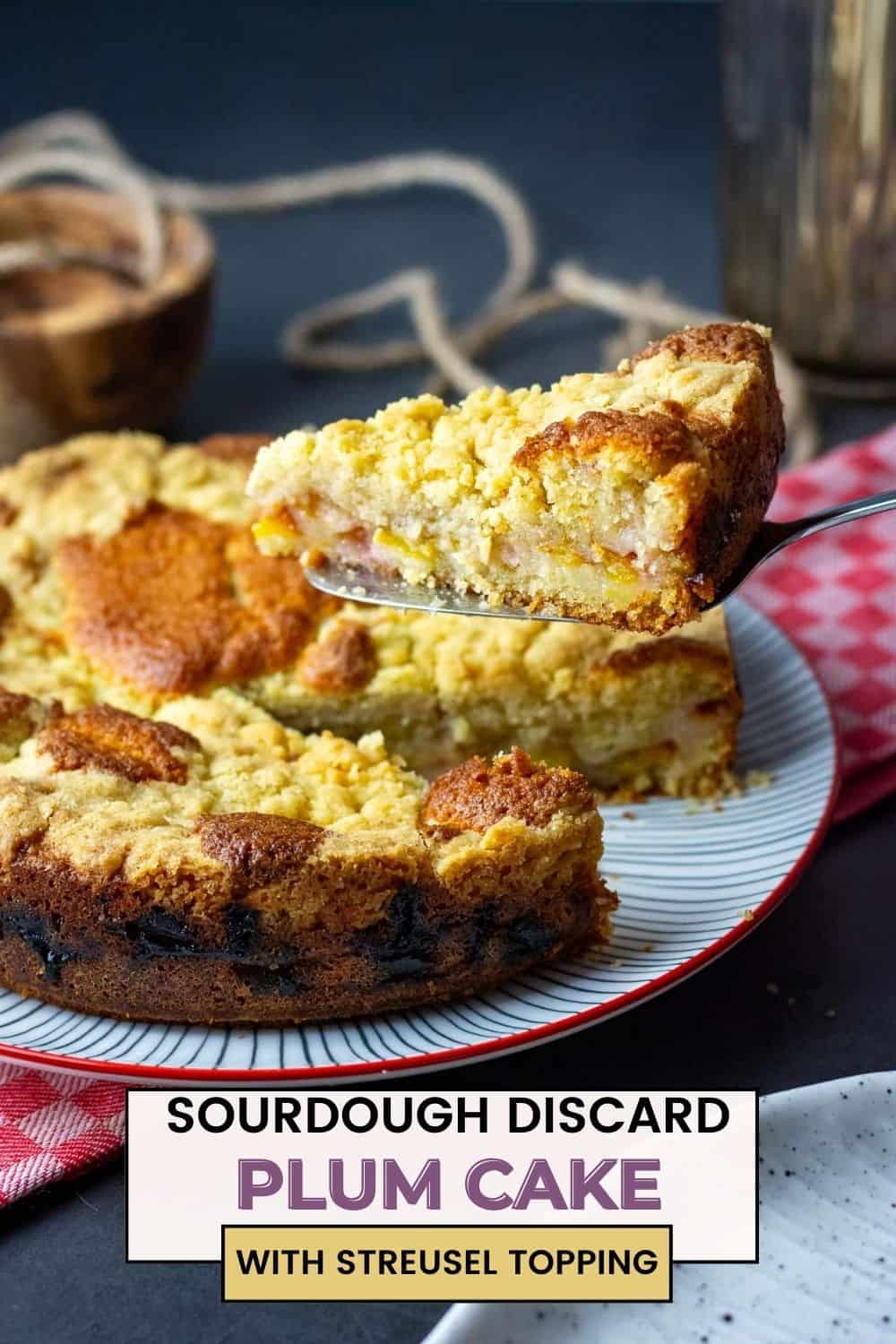 Sourdough Plum cake slice hovering above the rest of the sourdough cake. - Pin for Pinterest.