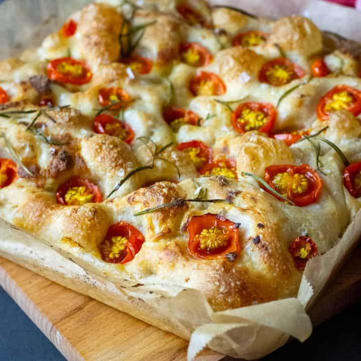 Sourdough Cherry Tomato Focaccia on a wooden board.