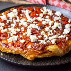 Cherry Tomato Tarte Tatin with feta on a black plate.