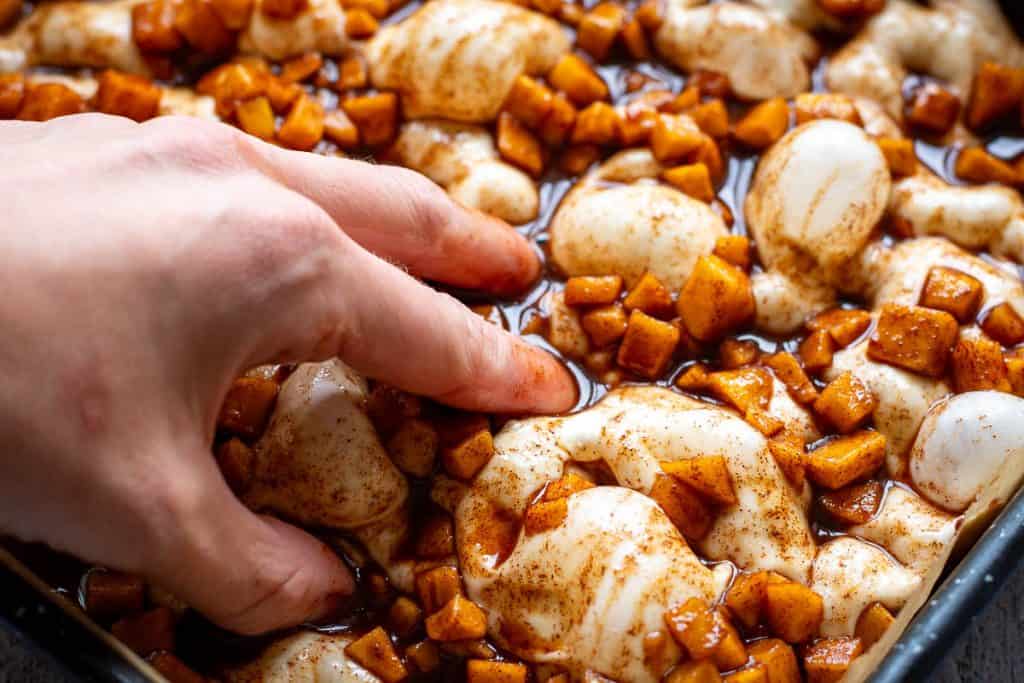 Dimpling cinnamon apple sourdough focaccia with iled fingers.