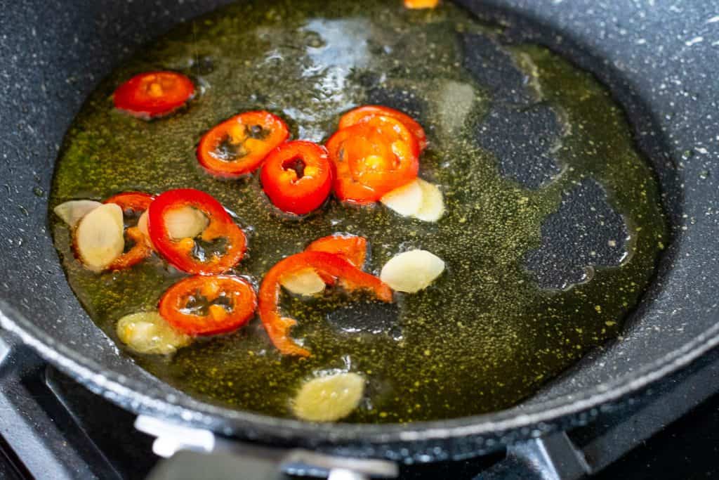 Sauteeing garlic and chilli in oil.