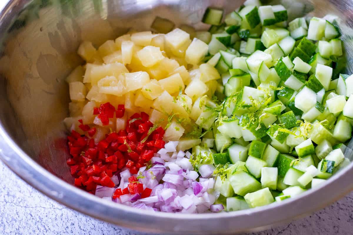 All shopped veggies and pineapple in a large mixing bowl.