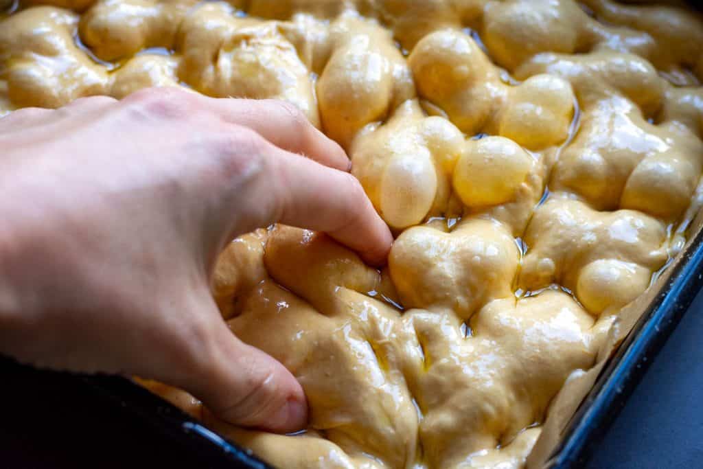 Dimpling the focaccia with oiled fingers.