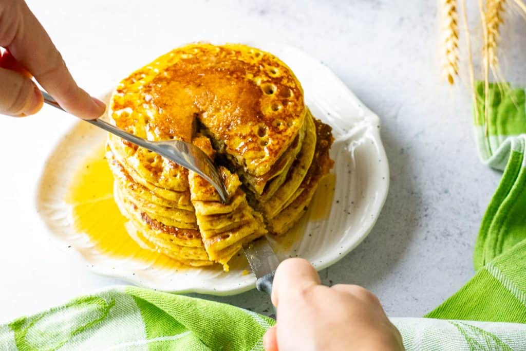 Cutting into a stack of sourdough pumpkin pancakes.