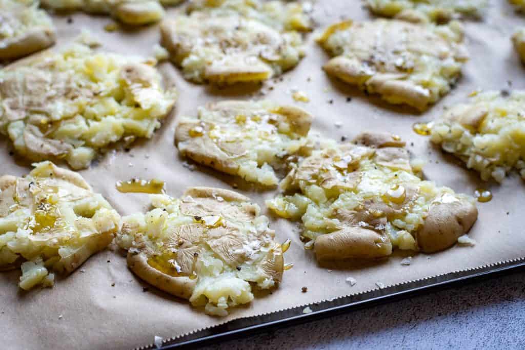 Smashed potatoes with a drizzle of oil and seasoning on top.