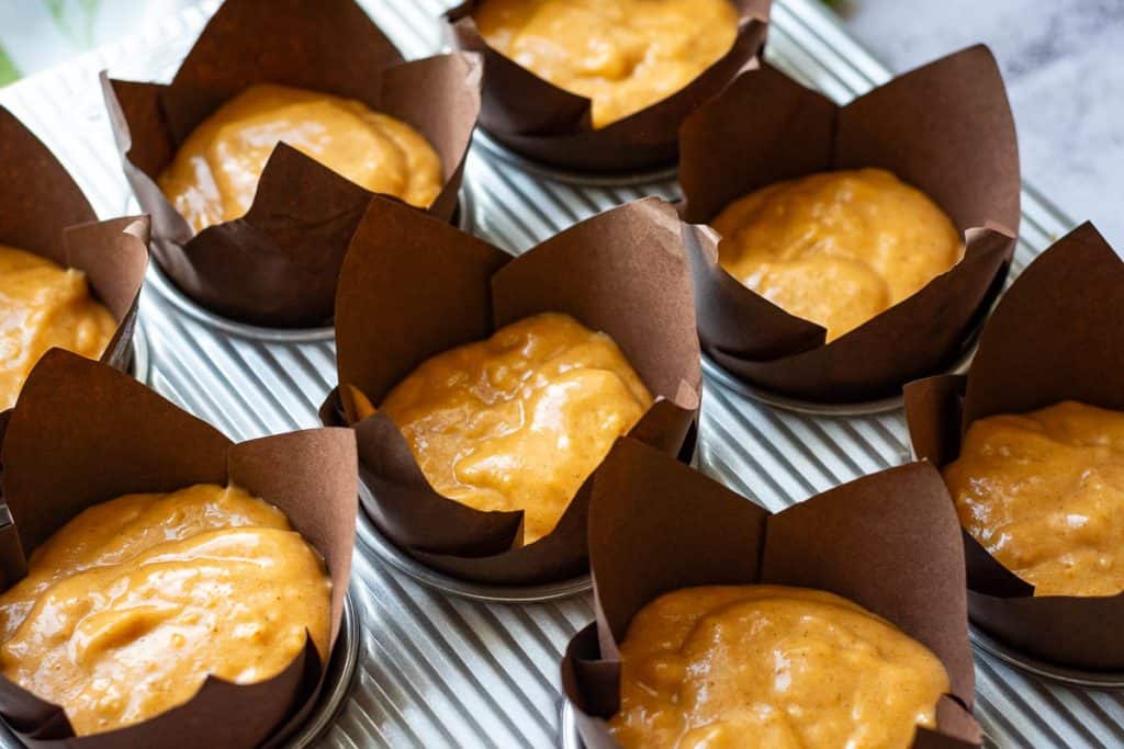 Sourdough pumpkin muffin batter in paper liners.