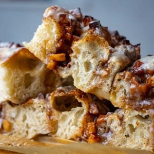 Cinnamon Apple Sourdough Focaccia cut into squares and stacked on a wooden board.