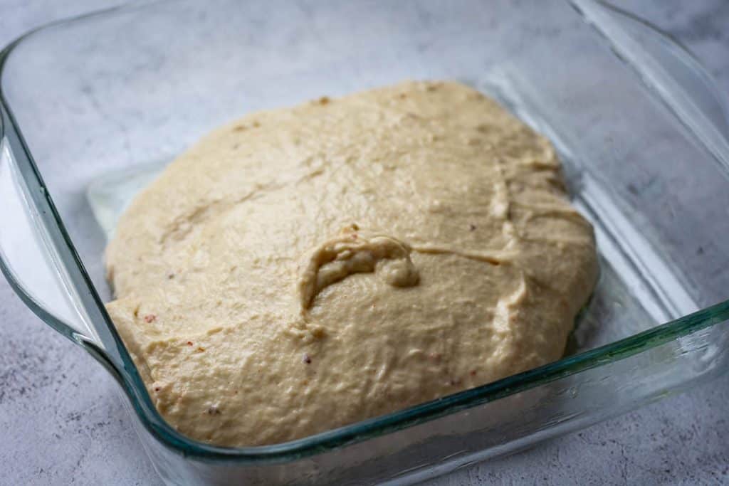 Hot honey sourdough focaccia dough in a glass container before cold folds.