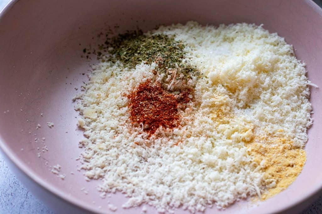 Grated parmesan, spices and dried herbs in a bowl.
