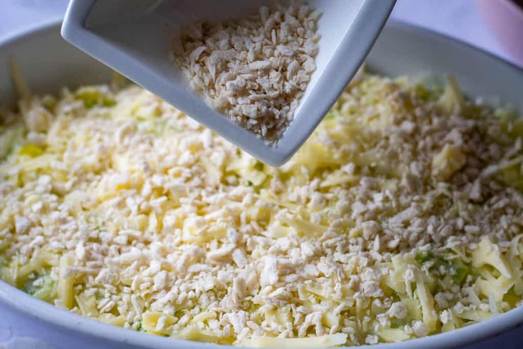 Scattering panko breadcrumbs ove cheesy leeks.