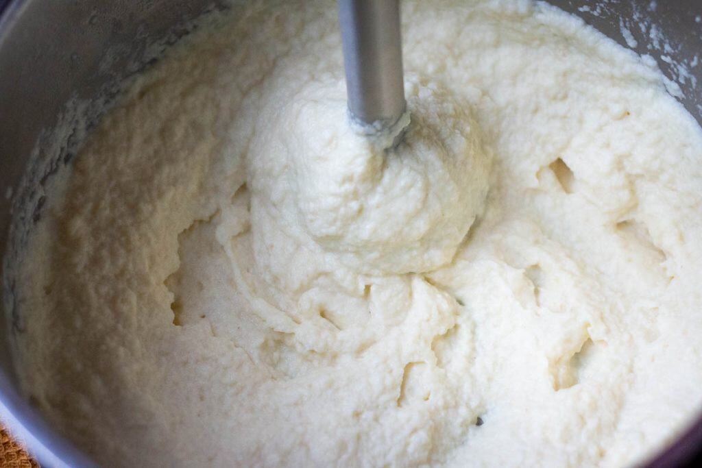 Using a hand blender to make celeriac puree.