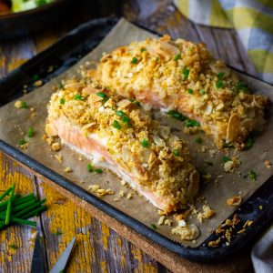 Panko and Almond Crusted Salmon on a parchment paper lined baking tray.