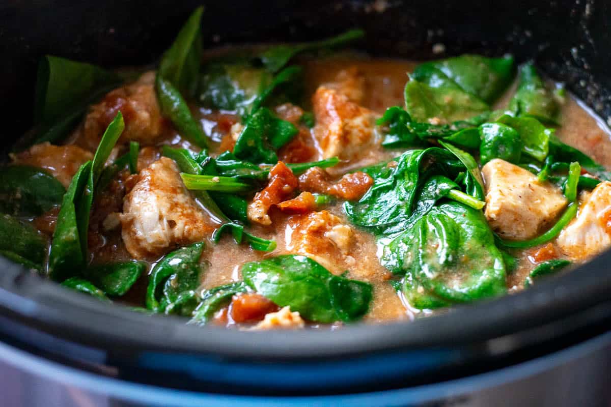 Wilted spinach in the slow cooker Tuscan Chicken.