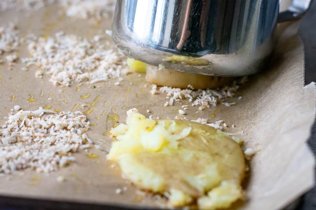 smashing the potatoes with the base of a metal jug.