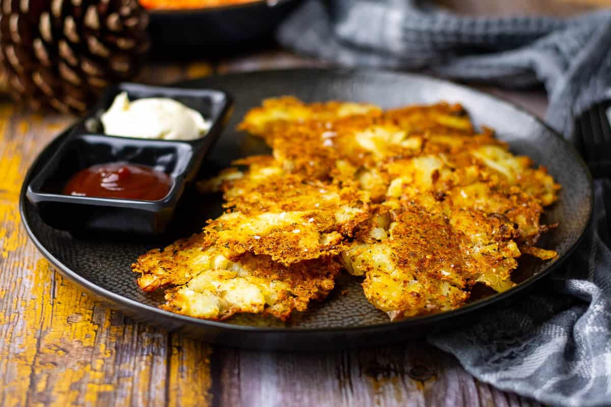 Parmesan Smashed Potatoes on a black plate with two dips.