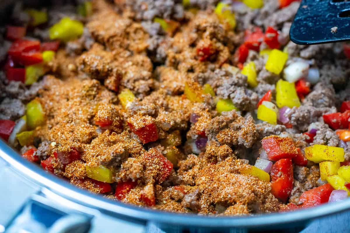 Spices and peppers added to the cooked ground beef pan.